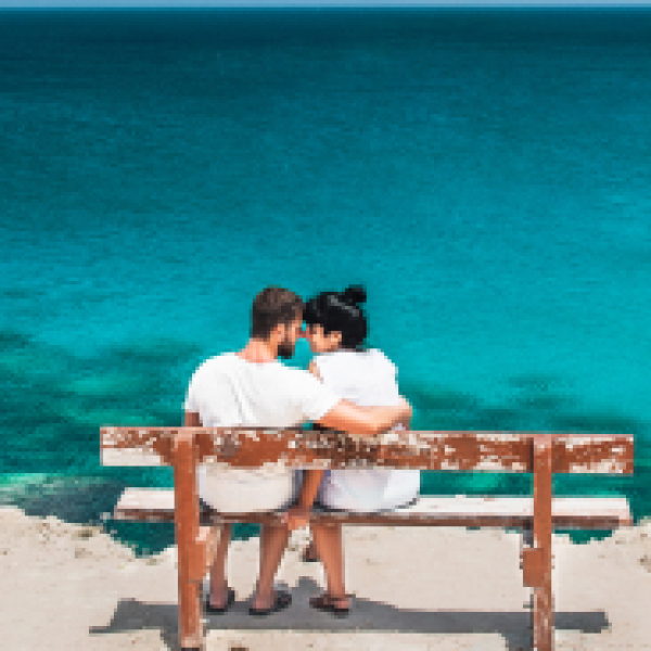 honeymoon-traveller-couple-hugging-on-a-wooden-ben-2023-11-27-05-33-52-utc